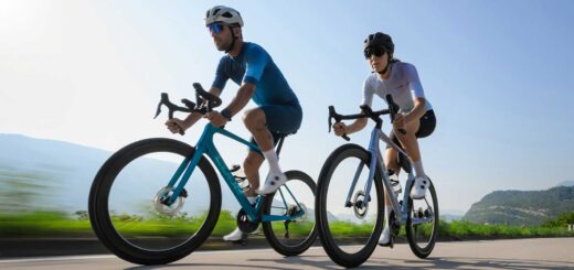Deux cyclistes sur route (un homme et une femme) roulent sur un vélo Cube 2026 en action.