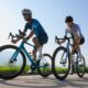 Deux cyclistes sur route (un homme et une femme) roulent sur un vélo Cube 2026 en action.