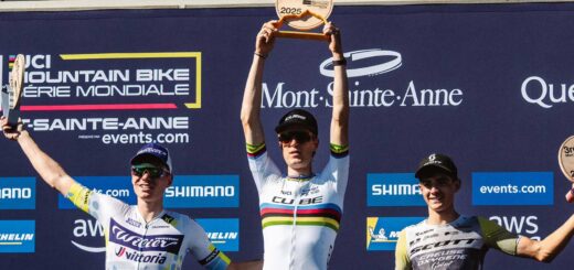 Finn Treudler célèbre la finale de la saison du Cube Factory Racing 2025 à Mont-Sainte-Anne, tenant le trophée dans ses mains, entouré des deuxième et troisième coureurs sur le podium.