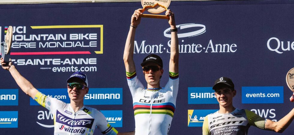 Finn Treudler célèbre la finale de la saison du Cube Factory Racing 2025 à Mont-Sainte-Anne, tenant le trophée dans ses mains, entouré des deuxième et troisième coureurs sur le podium.