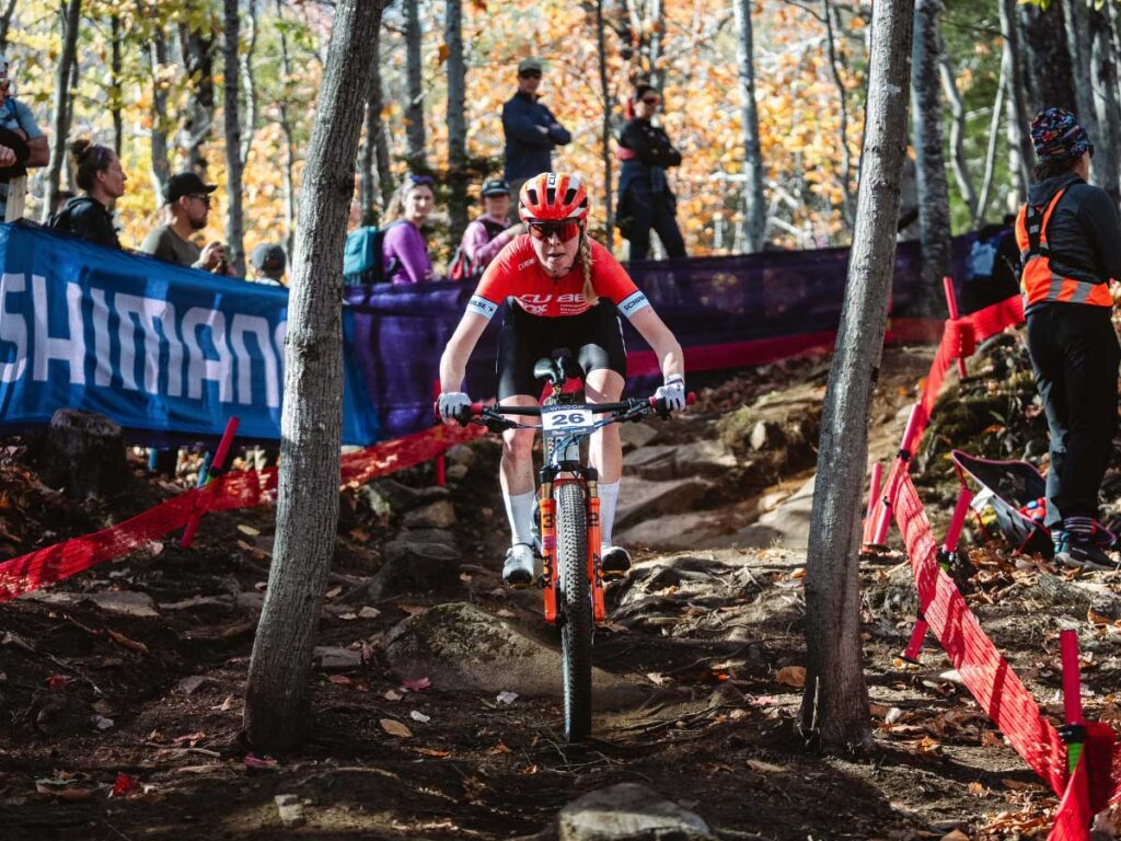 Kira B&ouml;hm roule avec une concentration totale &agrave; travers la section foresti&egrave;re technique lors de la finale de saison Cube Factory Racing 2025 &agrave; Mont-Sainte-Anne sur son VTT Cube.