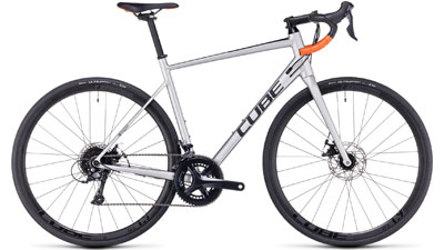 Vélo de course Cube Attain Pro en argent avec poignées de guidon Dropbar orange.