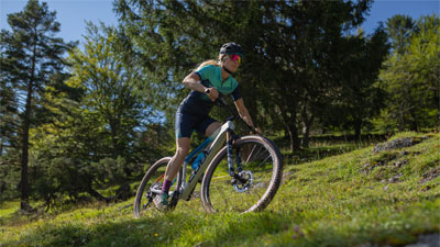 On voit une cycliste sur son VTT. Elle roule dans une zone escarpée.