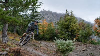 Cycliste roulant dans la forêt sur un vélo tout terrain Cube Stereo Fully.