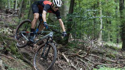 On voit une cycliste qui descend une pente à vélo.